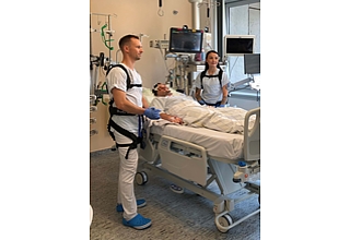 Zwei Pflegekräfte mit angelegtem Exoskelett im praktischen Einsatz auf der neurologischen Intensivstation an der Universitätsklinik für Neurochirurgie Magdeburg. Fotografin: Melitta Schubert/Universitätsmedizin Magdeburg